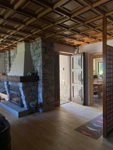 a large living room with a stone fireplace at Chalet il pino in San Bernardo