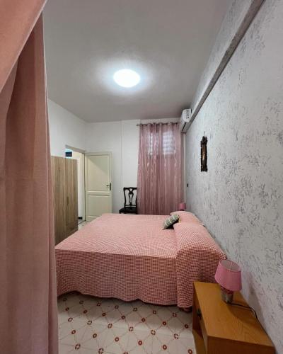 a bedroom with a pink bed in a room at Residence Toscano in Palmi
