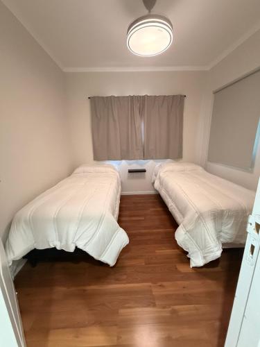 two beds in a small room with a window at APART-Esperanza in Esperanza