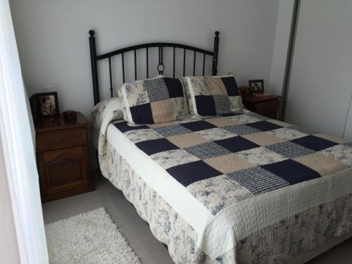 1 dormitorio con 1 cama con manta blanca y negra en Apartamento Vista Brava, en Punta del Este