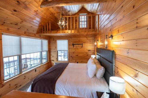 a bedroom with a bed in a wooden cabin at Presidential Mountain Resort in Bethlehem