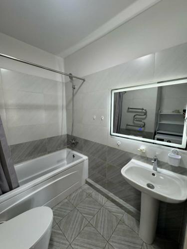 a bathroom with a sink and a toilet and a tub at Miga's guest house & tour in Ulaanbaatar