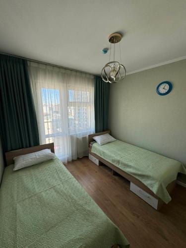 a bedroom with two beds and a clock on the wall at Miga's guest house & tour in Ulaanbaatar