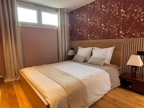 a bedroom with a large white bed and a window at Le Cap Saint Jacques Chambre d hôtes proche de bayeux à 15 mn idéal plages du débarquement in Putot-en-Bessin