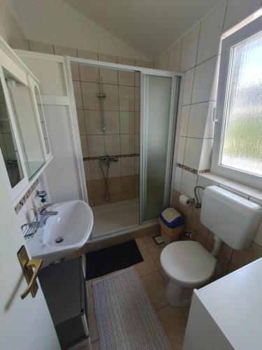 a bathroom with a toilet and a sink and a shower at Marica Dedić in Barbat na Rabu