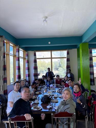 a group of people sitting at a table in a restaurant at Kepal Inn Hotel and Restaurant in Holshāl