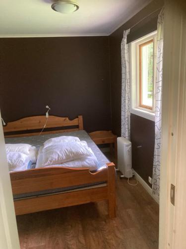 a bedroom with a bed and a window at Magsjön in Surahammar
