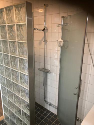 a bathroom with a shower and tiled walls at Magsjön in Surahammar
