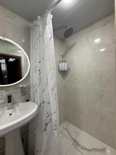 a white bathroom with a sink and a shower at Sant House Dilijan in Dilijan