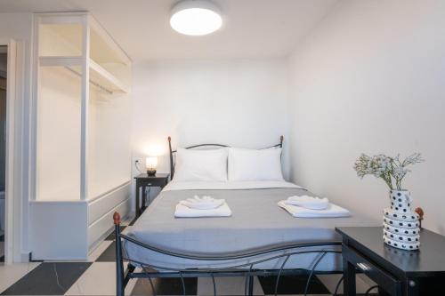 a bedroom with a bed and a table with towels at Aplo Chios Deluxe Apartments in Chios