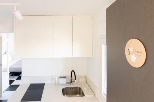 a kitchen with white cabinets and a sink at Aplo Chios Deluxe Apartments in Chios