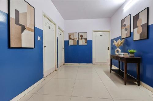 a hallway with blue and white walls and a table at DG Hotel Green Vista in Jaipur