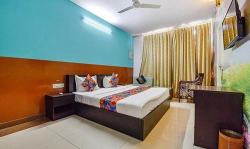 a bedroom with a bed and a blue wall at DG Hotel Green Vista in Jaipur