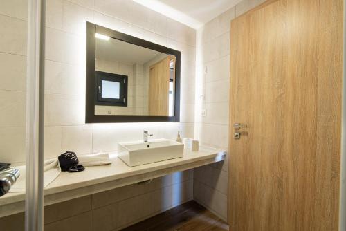 a bathroom with a sink and a mirror at Cynthia in Nea Vrasna