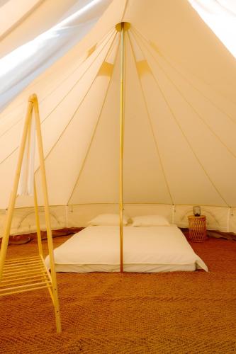 a bed in a marquee with a white tent at Aluna Camp in Nudo