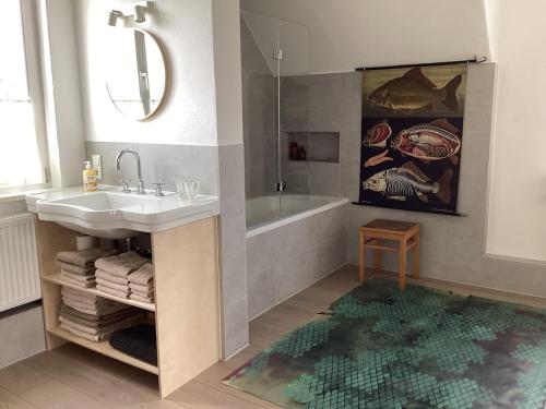 a bathroom with a sink and a tub and a rug at Hahnhaus in Burscheid