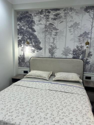 a bedroom with a bed with a floral bedspread at Lola in Osh