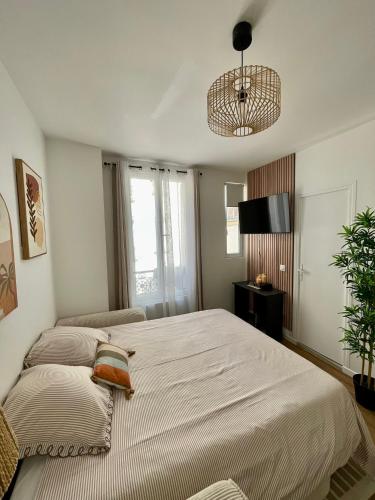 a bedroom with a large bed and a television at Votre cocon parisien in Bagnolet