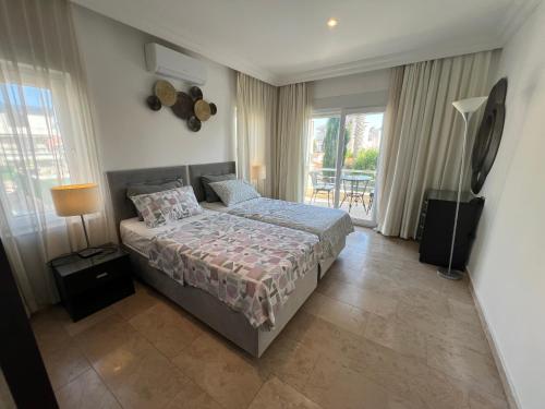 a bedroom with a bed and a balcony at VillaBelek in Belek