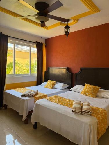 two beds in a bedroom with a ceiling at HotelJosefadeMaria in Izamal