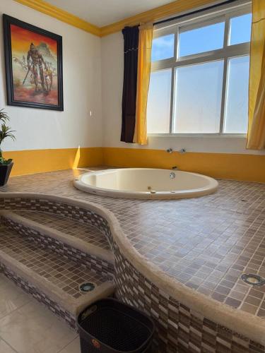 a bath tub in a room with a window at HotelJosefadeMaria in Izamal