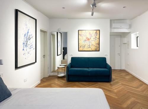 a living room with a blue couch in a room at The Mamas in Oristano