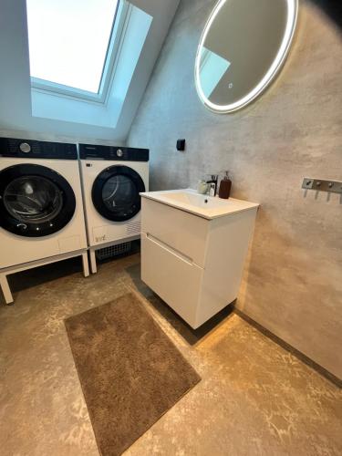 a bathroom with two washing machines and a sink at Modern nyproduktion nära ALV in Vimmerby