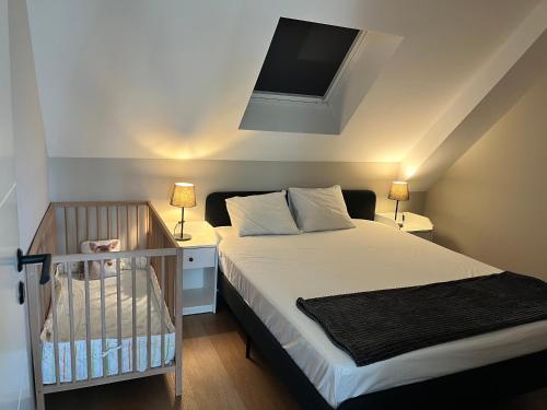 a bedroom with a bed with two lamps and a crib at Modern nyproduktion nära ALV in Vimmerby