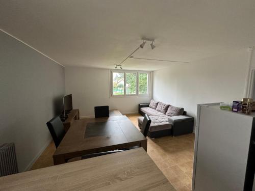 a living room with a couch and a table at Location chambre rouge dans un appartement en colocation in Nevers