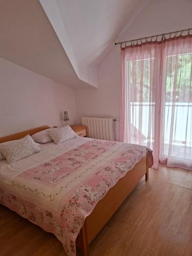 a bedroom with a large bed and a window at Apartments Elvira in Sveta Nedelja