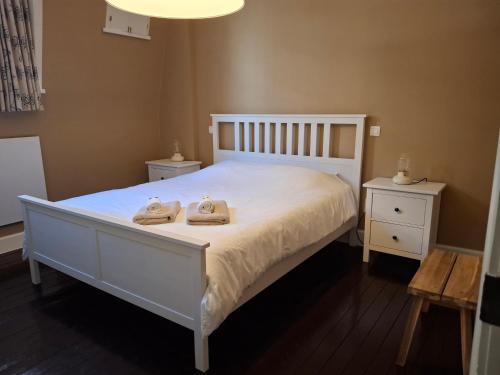 a bedroom with a white bed with two towels on it at Het Koetshuis, op 50m van zee, voor 5 personen, centrum Westende BAD, alle comfort in Middelkerke