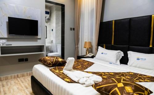 a hotel room with two beds and a flat screen tv at Travellers Palace Hotel in Kampala