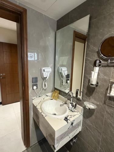 a bathroom with a sink and a mirror at ساتورن هاوس للشقق الفندقية in Tabuk
