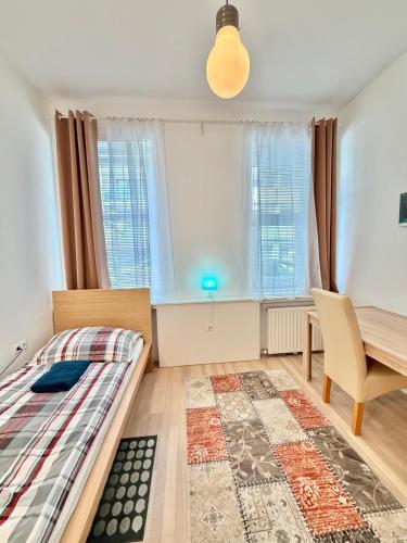 a bedroom with a bed and a table and window at FAVORIT-ROOMS , direkt Metro connection U1 to Centralstation-Airport and City-Center in Vienna