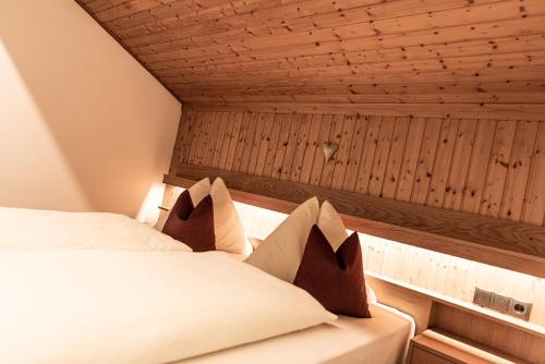 a bed in a room with a wooden ceiling at Haus Lohengrin Ferienwohnung 5 in Siusi