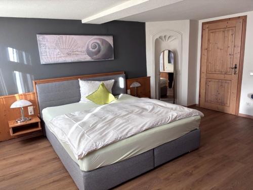 ein Schlafzimmer mit einem großen Bett und einem gelben Kissen in der Unterkunft Ochsen Hardheim in Hardheim