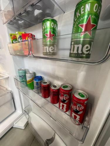 an open refrigerator filled with cans of soda at Casa Alto Padrão 3 Quartos - Perto do Shopping Sinop in Sinop