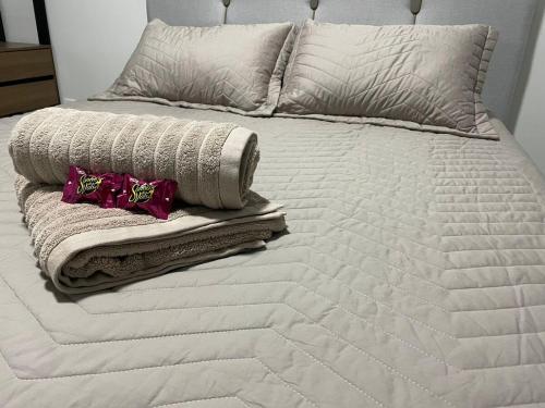 a white bed with towels and pillows on it at Casa Alto Padrão 3 Quartos - Perto do Shopping Sinop in Sinop