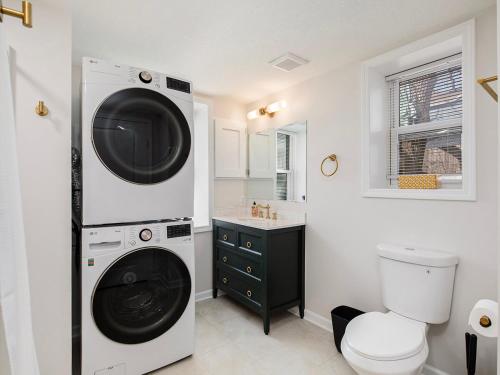 a washer and dryer in a bathroom with a toilet at Charming 3BD 2BR Dog Friendly in Overland Park