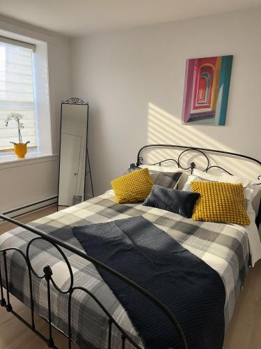 a bedroom with a bed with yellow and black pillows at Private Spacious Walkout Suite Near Downtown in Halifax