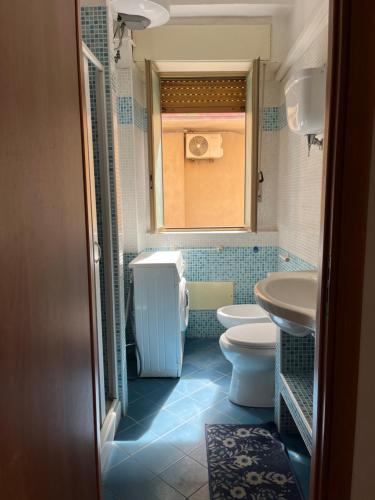a bathroom with a sink and a toilet and a window at La casa del professore libeccio in Nicotera Marina