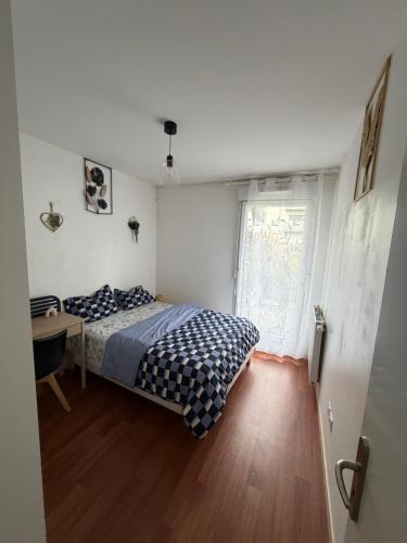a bedroom with a bed and a desk and a window at Patty Home Stay in Carrières-sous-Poissy