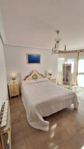 a bedroom with a large white bed in a room at Enoturismo-Noja in Noja