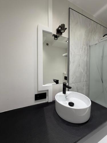 a white bathroom with a sink and a mirror at Host-X Pokoje Ciche Centrum Mała Sienkiewicza -fv in Kielce