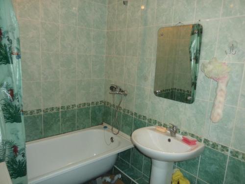 a bathroom with a sink and a toilet and a tub and a sink at Apartment on Komsomolskaya 8 in Kirov