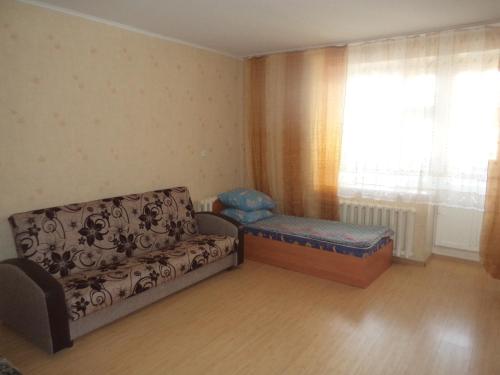 キーロフにあるApartment on Komsomolskaya 8のリビングルーム(ソファ、ベッド、窓付)