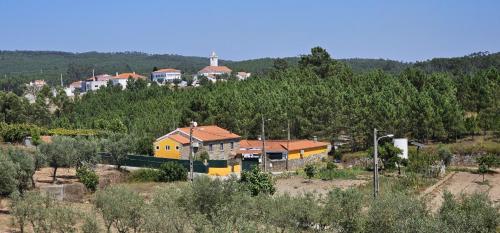 a group of houses on a hill with trees at Quinta Penedo das Antas in Sertã