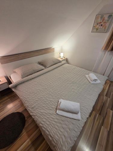 a bedroom with a large bed with two towels on it at Apartments Luka in Rakovica