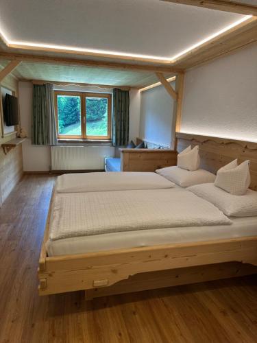 a large bedroom with two beds and a window at Apart Alpenpension Maderer in Gaschurn