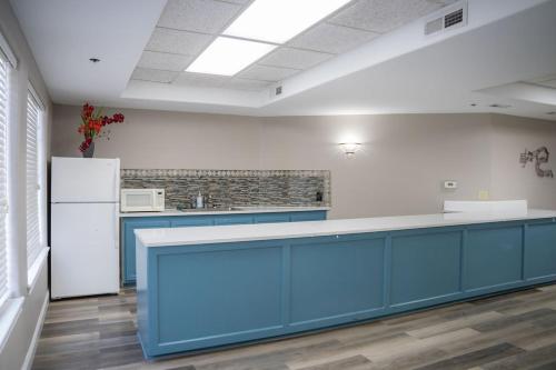 a kitchen with blue cabinets and a white refrigerator at Branson Towers Hotel in Branson